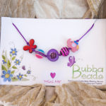 Red butterfly and pink elephant on purple cord